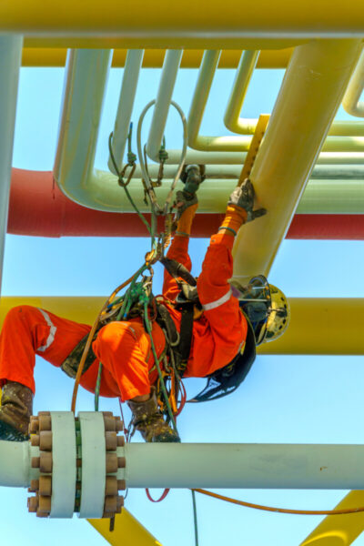 Arbeiter klettert unter rohren