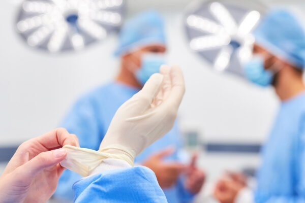 Ein Chirurg zieht sterile Handschuhe an
